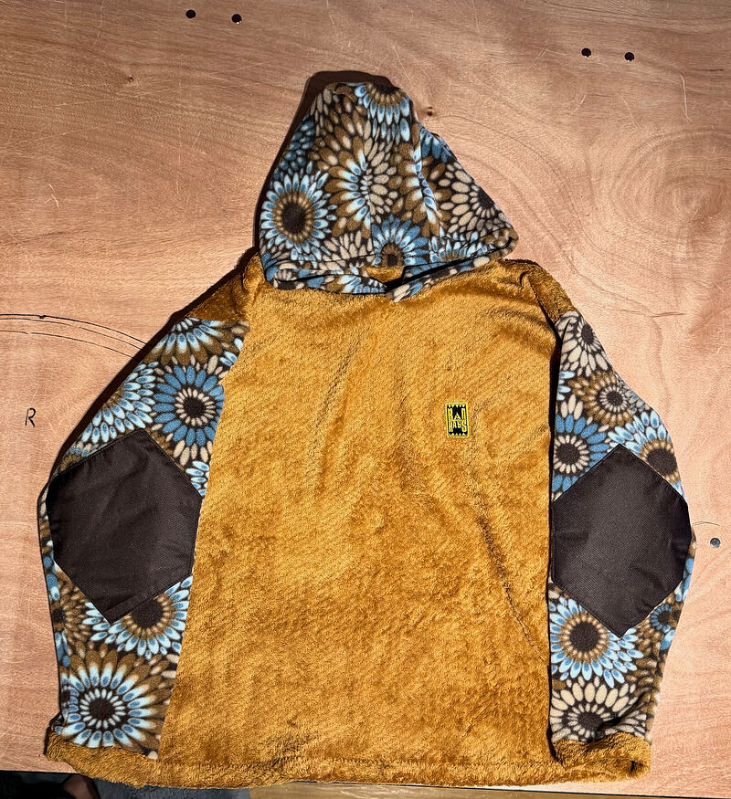 Fuzzy mustard fleece hoodie with a blue sunflower-print hood and sleeves and brown elbow patches