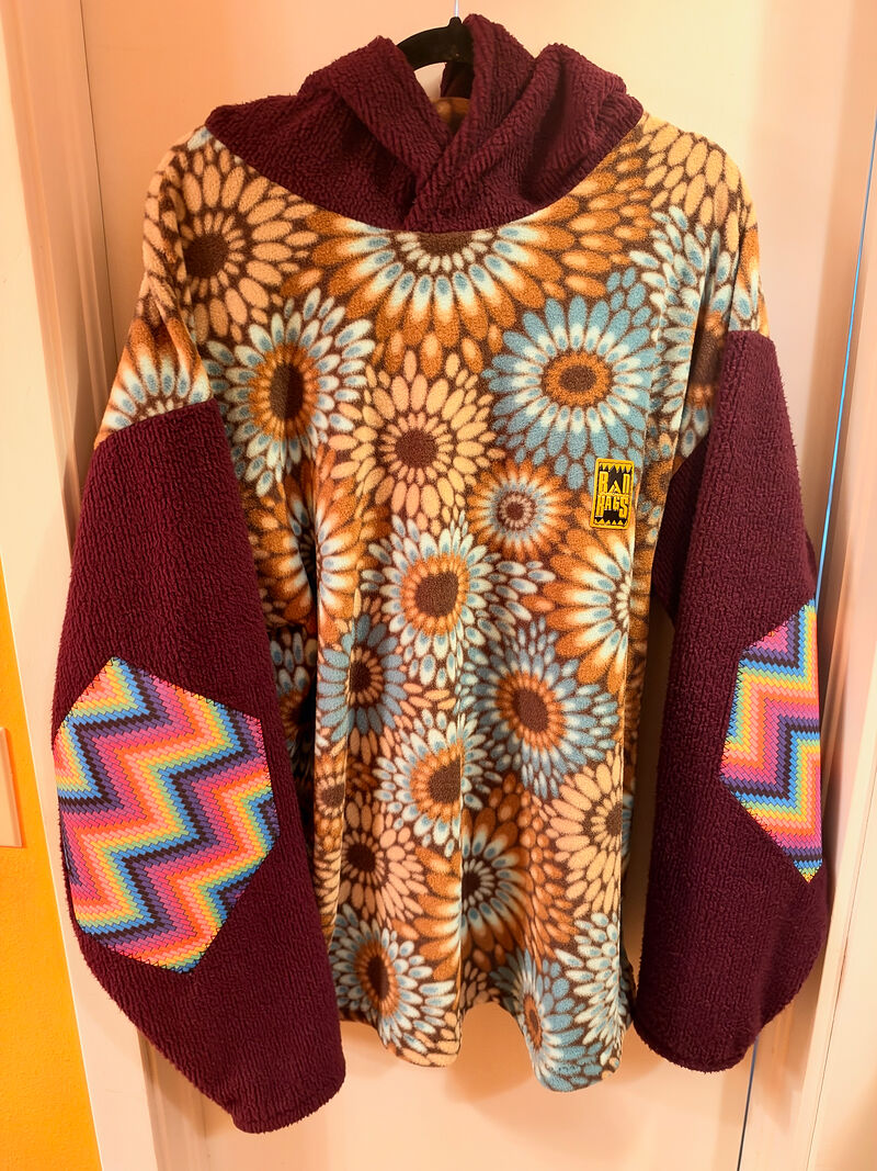 Sunflower-print fleece hoodie with maroon sherpa sleeves and zigzag elbow patches