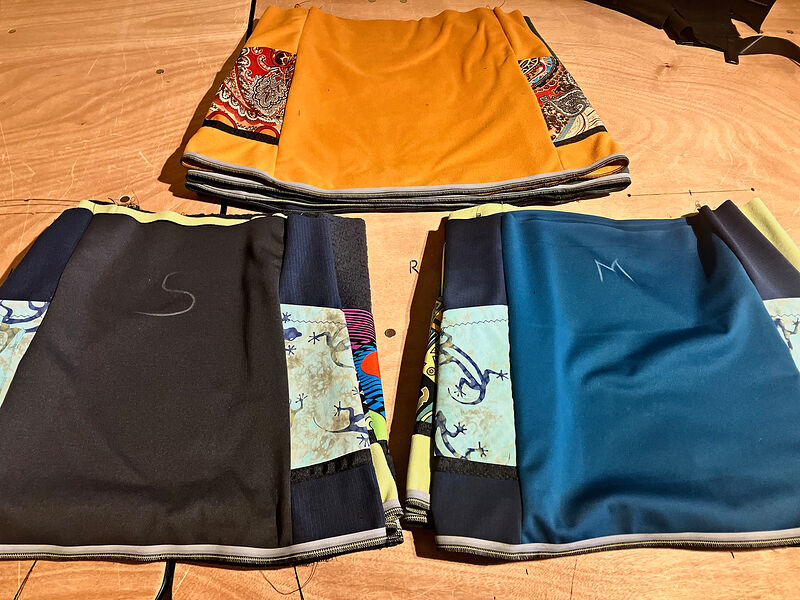 Three fleece skirts with patterned side panels laid out on a table