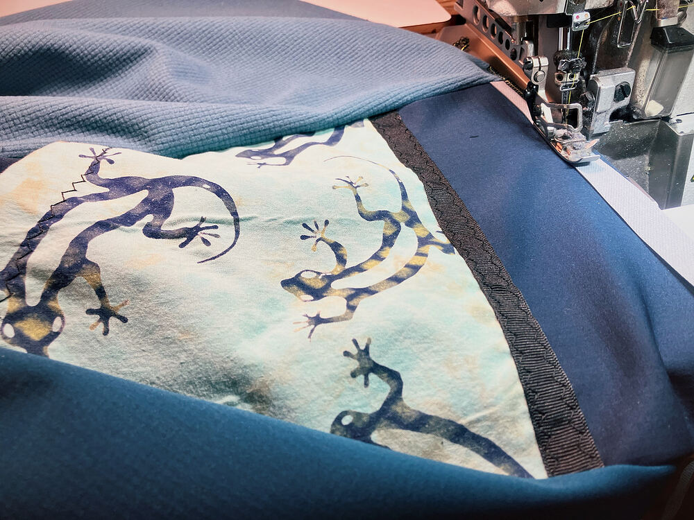 Sewing a gecko-print panel onto blue fleece