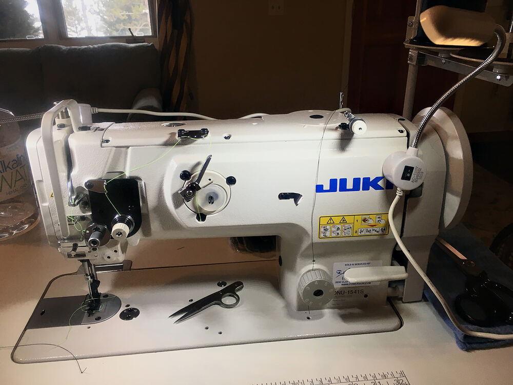 A Juki industrial sewing machine with thread snips on the table