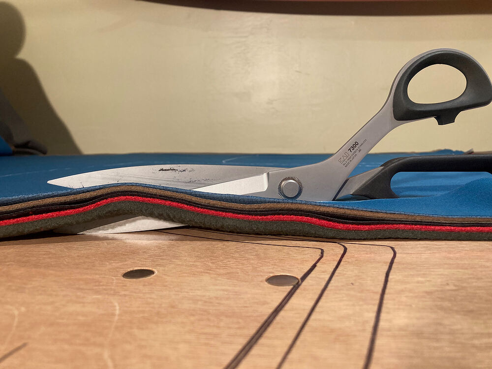 Big shears cutting through stacked fleece layers