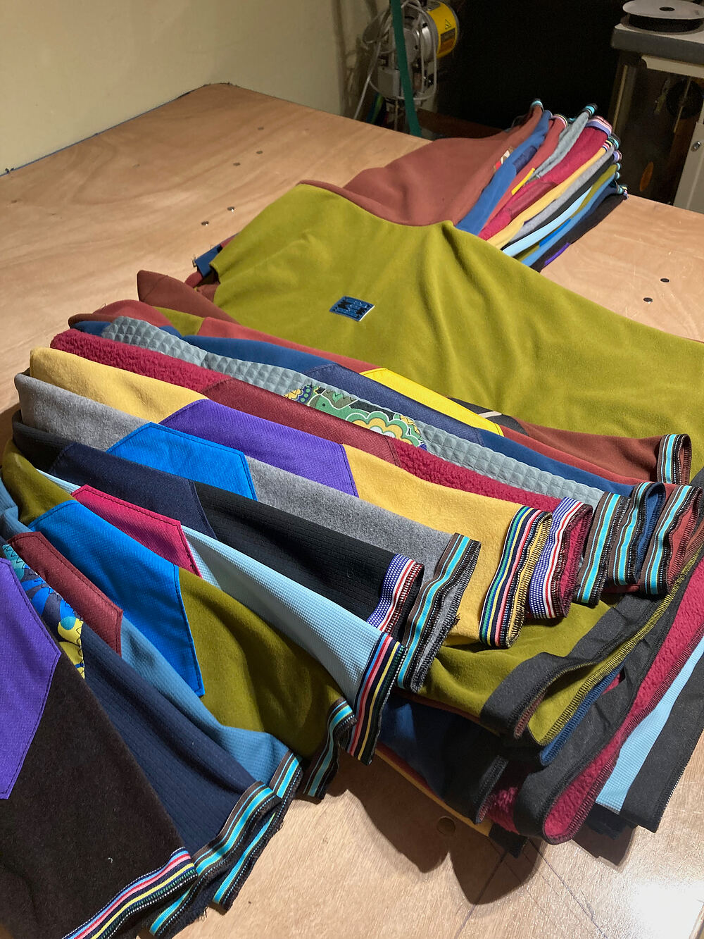 A stack of finished patchwork fleece with striped cuffs