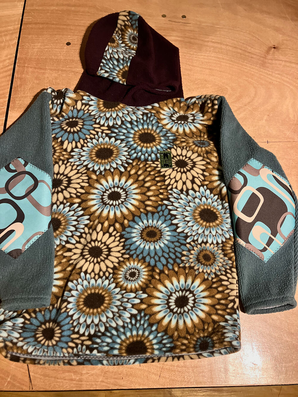 Sunflower-print fleece pullover with grey sleeves and retro elbow patches