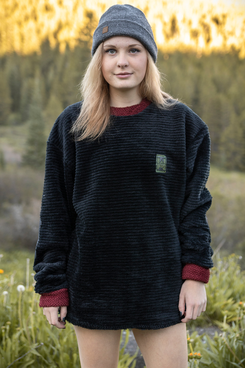 Model in a black fleece and gray beanie at golden hour