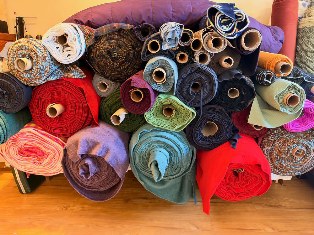 A wall of colorful fleece rolls stacked high in the shop