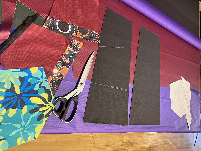 Cut fleece and printed fabric pieces with scissors on a cutting table