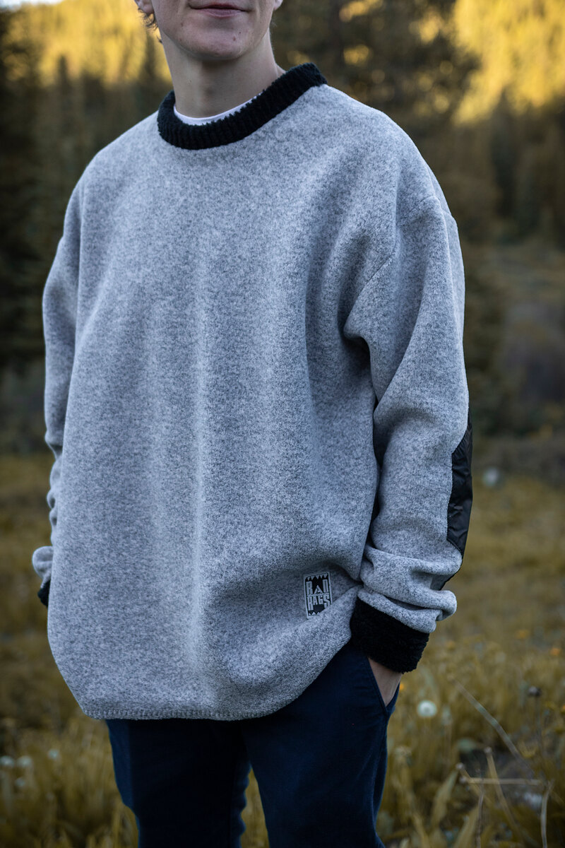 Model in a heather gray crewneck with black trim