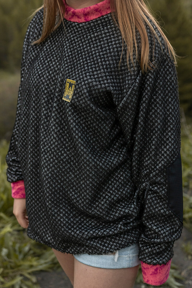 Model in a black and white houndstooth fleece with pink cuffs