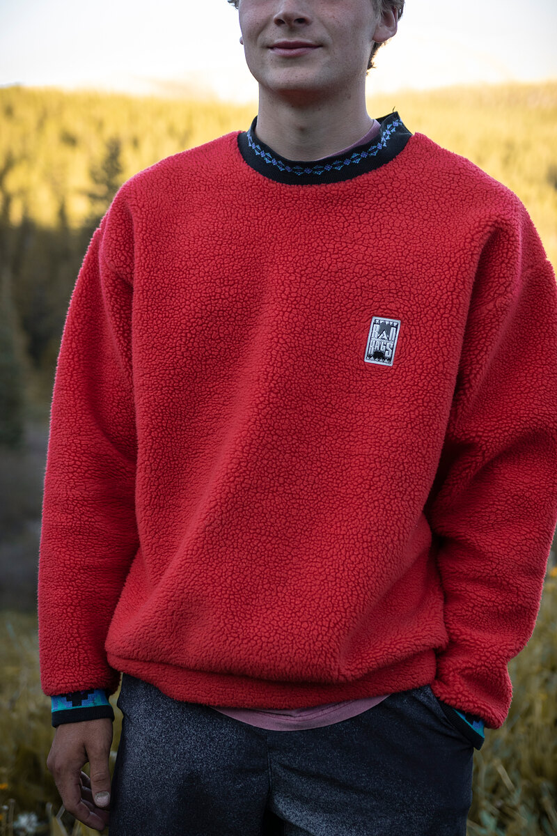 Model in a red fleece crewneck with a patterned collar