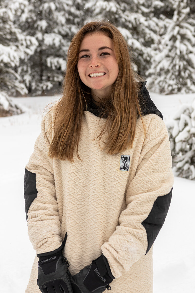 Smiling model in a cream sherpa pullover with black sleeves